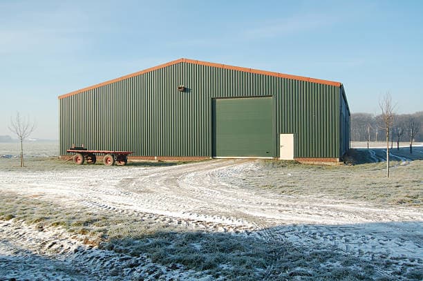 Green agricultural metal building in a rural setting